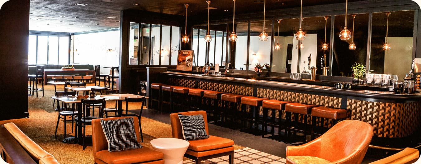 The dining room at Onijekuje Chopify, with warm lighting and orange leather seating around a long bar